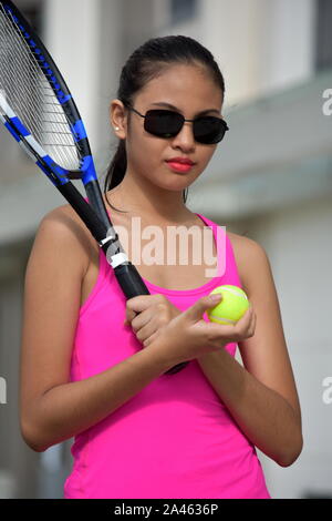 Impassibile atleta ragazza di minoranza giocatore di tennis di indossare occhiali da sole con la racchetta da tennis Foto Stock