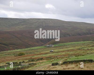 Un avvolgimento vicolo che conduce ad un secondo la guida Lonely farm house in una valle sulla Pennine Moors con streem dalle colline tra Yokshire e lancashire sulla A635 Foto Stock