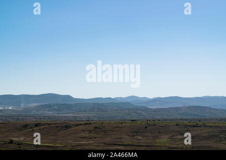 Paesaggio della Crimea. La steppa in primo piano e le montagne coperte di nebbia in background Foto Stock