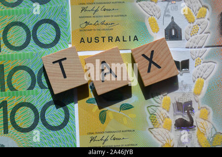 Imposta in 3d alfabeto di legno lettere su uno sfondo di Australian un centinaio di dollari di banconote. Foto Stock