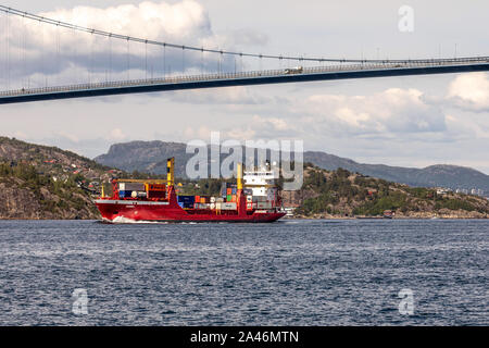 Contenitore piccolo peschereccio Rumba passando sotto Askoy (Askøy) sospensione ponte, al di fuori del porto di Bergen, Norvegia Foto Stock