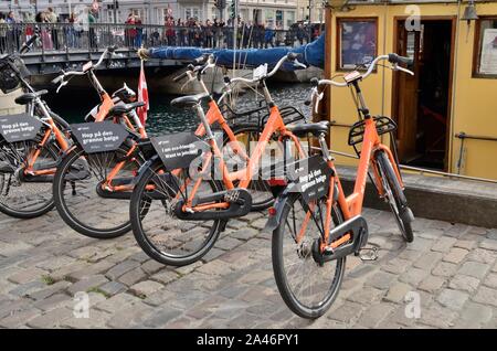 Copenhagen, Danimarca - 15 Settembre 2018: Orange biciclette parcheggiate accanto al canal a Copenhagen, in Danimarca. Foto Stock