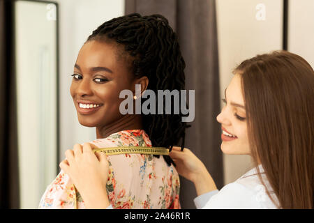 Designer di moda tenendo Lady's misure del corpo lavorano in atelier Foto Stock