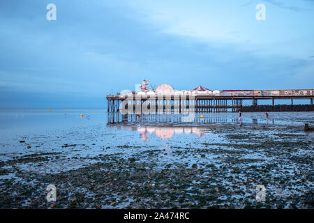 Guardando verso il molo di Herne Bay a bassa marea, con il suo riflesso sulla sabbia bagnata. Il molo ha una zona fieristica ed è noto per i granchi. Foto Stock