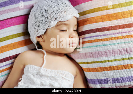 Calma sleeping Baby girl sopra vista dall'alto su sfondo colorato Foto Stock