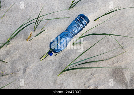 La bottiglia di plastica nella sabbia Foto Stock