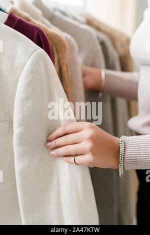 Mano di giovane donna azienda dal manicotto del giubbotto da nuova collezione stagionale Foto Stock