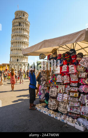 Un souvenir stallo nella famosa Piazza dei Miracoli con la Torre Pendente e i turisti in una soleggiata giornata estiva, Pisa, Toscana, Italia Foto Stock
