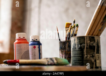 Set di pennelli in lattine di lattina e due vasetti di plastica con il rosso e il blu guazzo Foto Stock