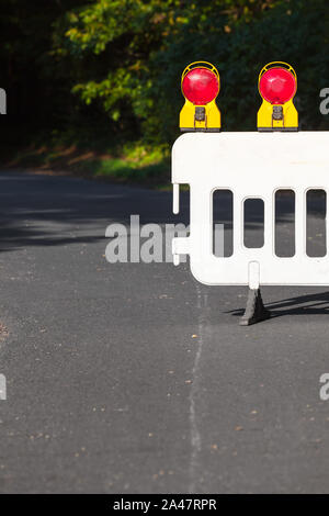 Dettaglio della barriera stradale con lampade di segnalazione a strada rurale (copia spazio) Foto Stock
