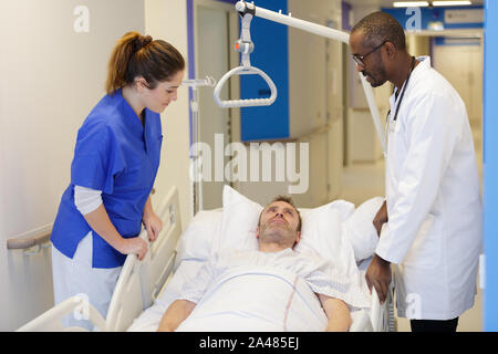 Il team medico frequentando paziente femmina sul letto di ospedale Foto Stock