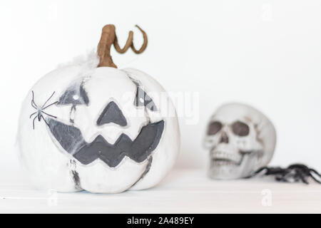 Scary bianco con zucca ragnatela e ragno e il cranio sullo sfondo. Concetto di Halloween Foto Stock