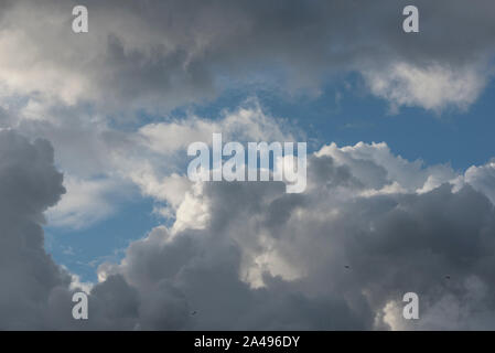 Il bianco e il grigio nuvole contro un cielo blu. Foto Stock