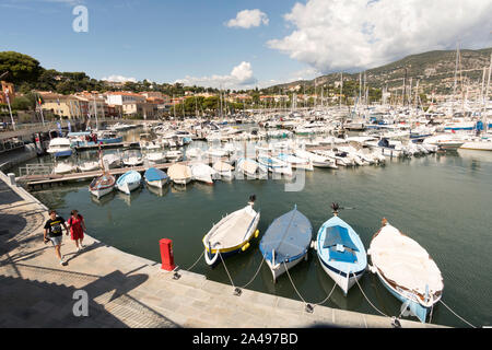 Giovane oltrepassando le barche ormeggiate nel porto turistico, Saint Jean Cap Ferrat, Francia Europa Foto Stock