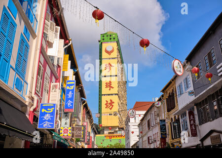 Vista attraverso Temple Street e la sua vecchia, rinnovato botteghe cinesi, a Chinatown, Singapore, verso il punto di riferimento di colore giallo popolare complesso di Parco Foto Stock