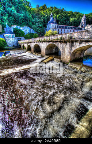 Brantome en Périgord, Francia. Il Pont Coude (angolo destro) a ponte sul fiume Dronne, con l'Abbazia di Brantome in background. Foto Stock