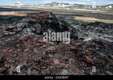 Leirhnjukur vecchio nero e rosso campo di lava con pietre colorate e il fumo proveniente da terra e cielo blu in Islanda, nuvoloso giorno in estate , film effe Foto Stock