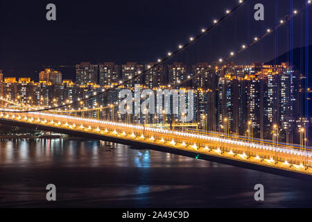 Il tramonto e la luce di illuminazione Tsing Ma Bridge landmark sospensione Ponte di Tsing Yi area di Hong Kong Cina. Foto Stock