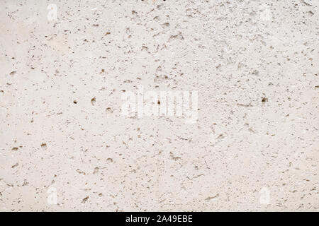 Materiale ruvido muro di cemento con superficie naturale di incrinature e fori Foto Stock