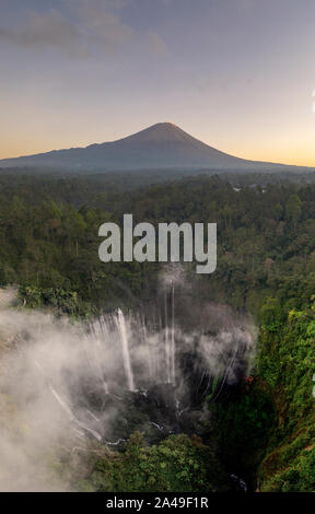 Antenna fuco immagine di Tumpak Sewu cascata con il Monte Semeru eruzione vulcanica in background in Java Orientale, Indonesia Foto Stock