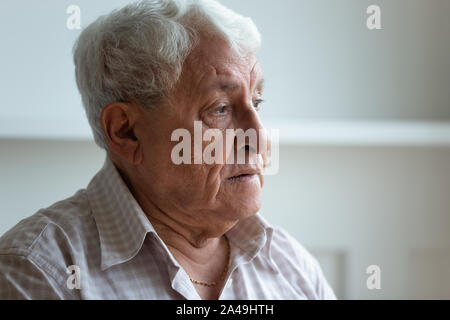 Uomo anziano si sente triste e solitaria che guarda lontano closeup faccia Foto Stock