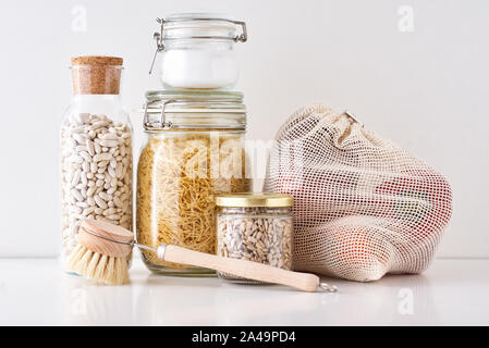 Vasi di vetro con ingredienti alimentari su sfondo bianco. Rifiuti Zero concetto. Cucina con sfondo eco friendly utensili Foto Stock