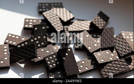 Un sacco di domino giacente nel caos sul tavolo soleggiato Foto Stock