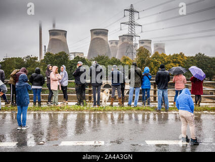 Ferrybridge, vicino a Leeds, Regno Unito. Il 13 ottobre 2019. Prima della demolizione, centinaia di persone si riuniscono sulla A162, a guardare quattro massicce torri di raffreddamento a Ferrybridge C Coal Fired power station di essere distrutto in un esplosione controllata. I residenti nelle vicinanze sono stati evacuati e il traffico sulla vicina autostrada M62 è stato portato a un arresto per consentire al piede 375 torri, che hanno retto dal 1966, per essere demolita. ©Ian Wray/Alamy Live News Foto Stock