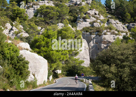 Ciclista femmina in bicicletta attraverso le Alpilles, vicino a San Remo, Francia. Foto Stock