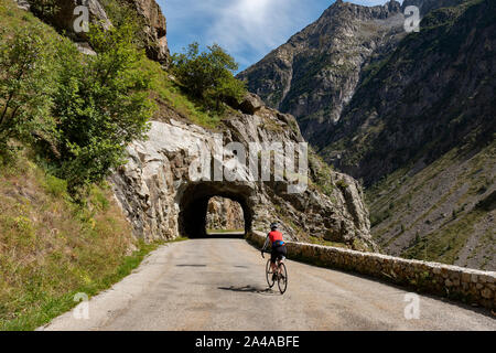 Femmina matura ciclista in sella alla strada tranquilla fino ti Saint Christophe Oisans, Alpi occidentali,Francia. Foto Stock