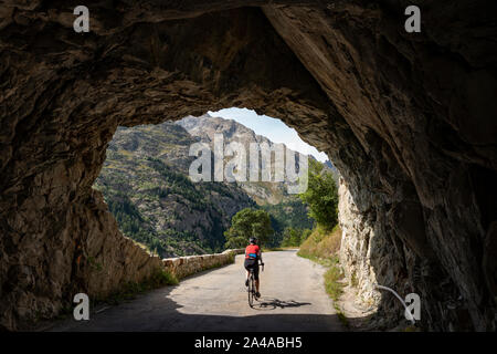 Femmina matura ciclista in sella alla strada tranquilla fino ti Saint Christophe Oisans, Alpi occidentali,Francia. Foto Stock