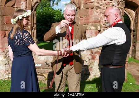 Questa immagine si riferisce a una cerimonia Handfasting nello Shropshire. Handfasting, secondo lo sposo, risale all XI secolo. Foto Stock