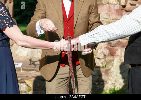 Questa immagine si riferisce a una cerimonia Handfasting nello Shropshire. Handfasting, secondo lo sposo, risale all XI secolo. Foto Stock