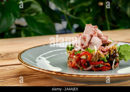 Gustosa insalata calda con verdure diverent come cipolla, peperone rosso. insalata verde e la carne, con mostarda. Foto Stock