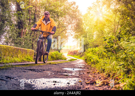 Escursioni in bicicletta in Irlanda. Ciclista ricreative in mountain bike sulla strada di campagna irlandese. Foto Stock
