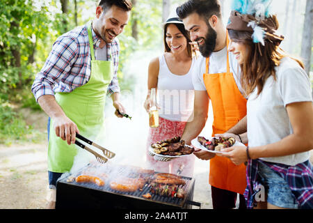 Amici divertendosi in natura facendo il barbecue Foto Stock