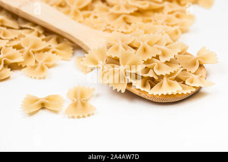 Farfalle su sfondo bianco. Materie non cotti legare a forma di prua italiano prodotto di maccheroni Foto Stock