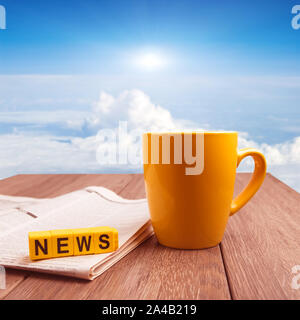 Buone notizie in mattina tempo collage immagine. La tazza di caffè e un giornale sul tavolo di legno all'orario di alba Foto Stock