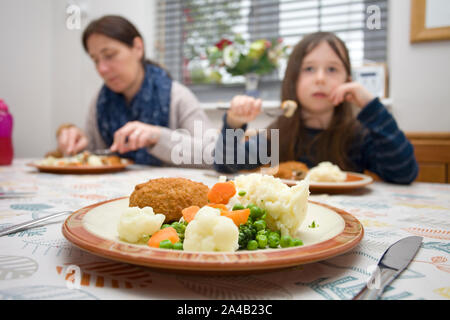 Bambino di mangiare al tavolo per la cena Foto Stock