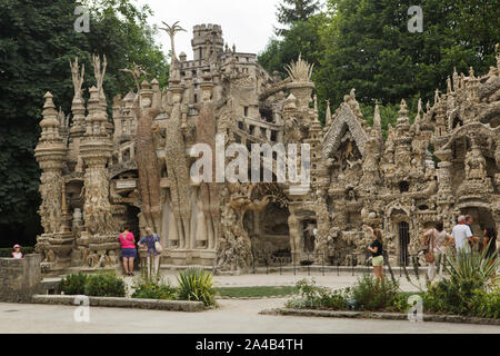 I visitatori di fronte al palazzo ideale (Le Palais idéal) progettato da postino francese Ferdinand Cheval e costruire dal 1876 al 1912 in HAUTERIVES, Francia. Dittatore romano Giulio Cesare, celtica re Vercingetorige e greco fisico e matematico Archimede sono rappresentati da sinistra a destra come i tre giganti sulla facciata est. Attenzione: Questa immagine è una parte di un saggio fotografico di 36 foto con il palazzo ideale (Le Palais idéal). Foto Stock