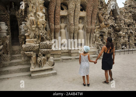 I visitatori di fronte al palazzo ideale (Le Palais idéal) progettato da postino francese Ferdinand Cheval e costruire dal 1876 al 1912 in HAUTERIVES, Francia. Due mummie egizie sono visto raffigurato sulla facciata est tra le gambe dei tre giganti. Attenzione: Questa immagine è una parte di un saggio fotografico di 36 foto con il palazzo ideale (Le Palais idéal). Foto Stock