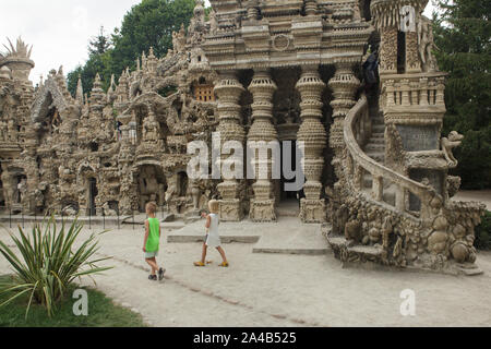 I giovani visitatori di fronte l'entrata del palazzo ideale (Le Palais idéal) progettato da postino francese Ferdinand Cheval e costruire dal 1876 al 1912 in HAUTERIVES, Francia. Attenzione: Questa immagine è una parte di un saggio fotografico di 36 foto con il palazzo ideale (Le Palais idéal). Foto Stock