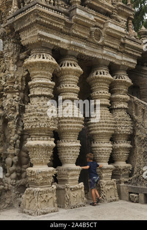 Giovane visitatore di fronte l'entrata del palazzo ideale (Le Palais idéal) progettato da postino francese Ferdinand Cheval e costruire dal 1876 al 1912 in HAUTERIVES, Francia. Attenzione: Questa immagine è una parte di un saggio fotografico di 36 foto con il palazzo ideale (Le Palais idéal). Foto Stock