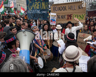 Dimostrazione e di protesta contro il Presidente Moreno la politica in Ecuador, la folla di persone in abiti tradizionali che mostra banner durante la riproduzione di musica Foto Stock