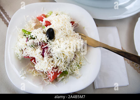 Bulgaro, serbo e macedone cucina tradizionale Shopsky o insalata shopska salata con pomodori, cetrioli, paprica, cipolla e formaggio di capra brynza. Foto Stock