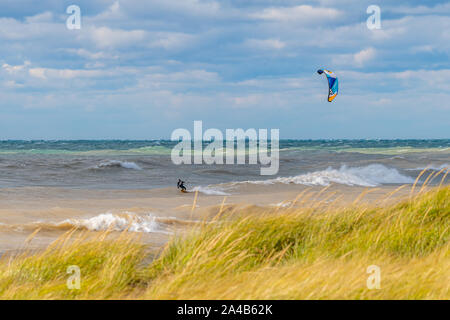 Un uomo kite surf in grandi onde del lago Michigan. Foto Stock