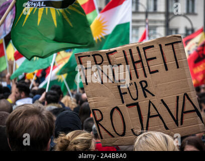 Dimostrazione e protesta contro offensiva turca in Siria contro i curdi, segno con la libertà per rojava in tedesco, le teste delle persone da dietro Foto Stock