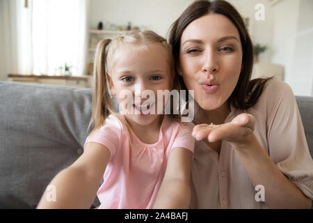 Colpo alla testa la figlia e la madre prendendo selfie, invio di blow kiss Foto Stock