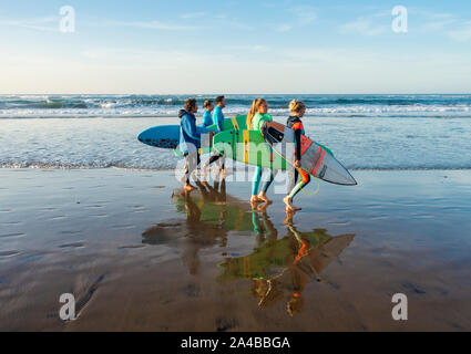 Un gruppo di giovani surfisti camminando sulla spiaggia. Playa de Las Canteras, Las Palmas di Gran Canaria Isole Canarie Spagna. Foto Stock