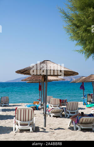 Spiaggia di sabbia bianca con ombrelloni di paglia e verdi alberi, Kos Dodecaneso ( dhodhekanisos), Grecia isola. Acquamarina turqouise acqua di mare Egeo ( med Foto Stock